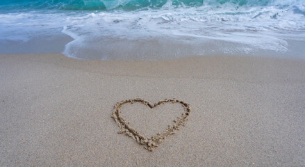 Heart drawn in sand. Waves forming a heart shape sign. Love on beach. Romantic summer. Heart made of sand. Love and ocean waves.