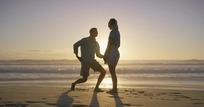 Beach, sunset and couple holding hands for proposal for romance, love and commitment offer. Engagement, holiday vacation or man on knee to ask woman question on valentines day or anniversary date