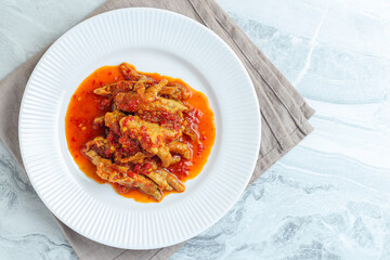 Dakbal. or Korean spicy chicken feet. Served on white plate.