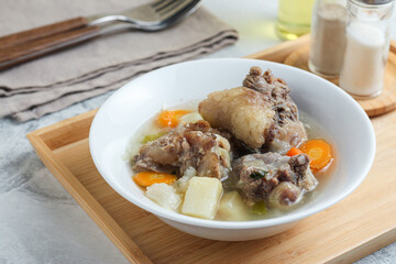 Beef vegetable soup served in a white bowl.