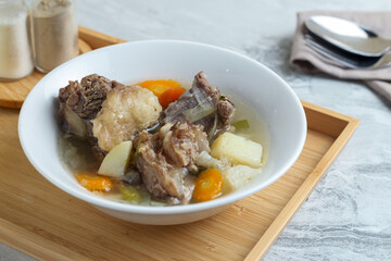Beef vegetable soup served in a white bowl.