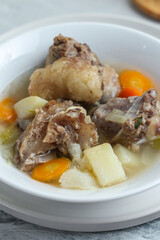 Beef vegetable soup served in a white bowl.