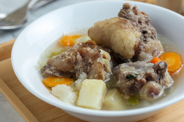 Beef vegetable soup served in a white bowl.
