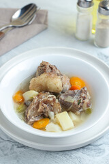 Beef vegetable soup served in a white bowl.