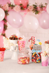 Candy bar. Many different sweets on table in festive decorated room