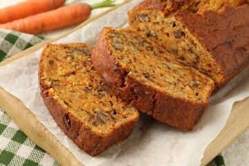 Homemade carrot cake with nuts and vegetables on table, closeup