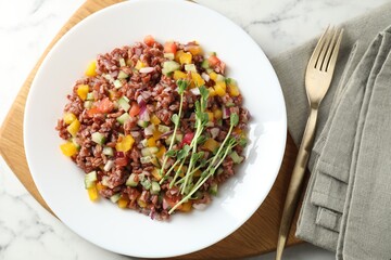 Tasty salad with brown rice served on white marble table, flat lay