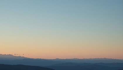 Obraz premium Tranquil landscape reveals distant mountains under soft pastel sky, evoking sense of peace and serenity. gentle gradient of colors enhances beauty of nature canvas