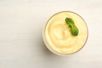 Tasty vanilla pudding with mint on white wooden table, top view. Space for text