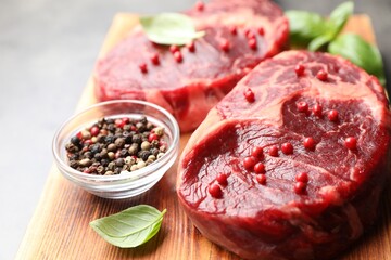 Pieces of raw beef meat and spices on gray table, closeup