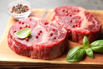 Pieces of raw beef meat and spices on table, closeup