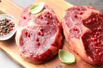 Pieces of raw beef meat and spices on table, closeup