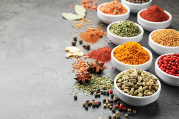 Different aromatic spices on grey table. Space for text