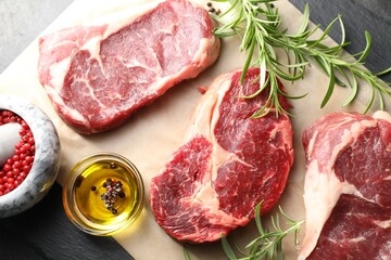 Pieces of raw beef meat and spices on table, flat lay