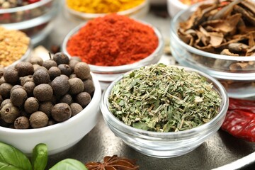 Different aromatic spices in bowls on table, closeup