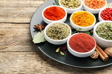 Different aromatic spices on wooden table, closeup. Space for text