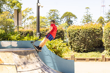 Teenage boy riding scooter on ramps at skate park