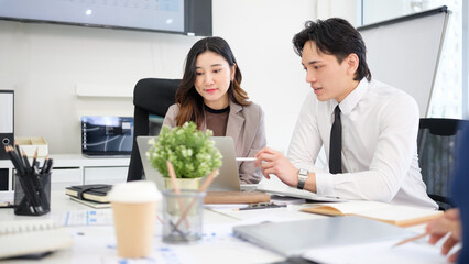 Focused business professionals reviewing plans and documents, representing teamwork, communication, and productivity in a corporate setting.