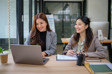 Confident businesswomen sharing ideas and planning projects in a bright, collaborative workspace.