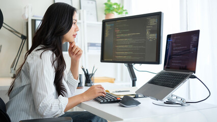 Woman focused on software development, surrounded by a clean and modern tech workspace with a...