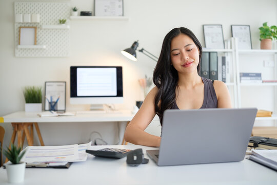 Young entrepreneur reviewing paperwork in a bright home workspace.