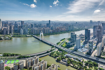 Obraz premium Aerial view of Guangzhou cityscape with bridge spanning river under blue sky, China. Urban development background.
