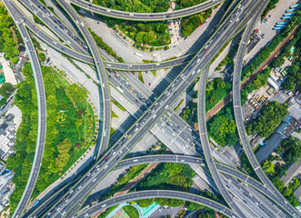 Top down aerial view of intricate highway interchange junction with traffic creating complex road...
