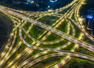 Aerial view of illuminated circular highway interchange roundabout with light at night.