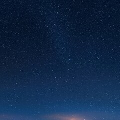 A majestic night sky with countless stars sparkling brightly over the quiet landscape below