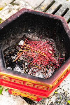 Burnt incense ashes in red burner