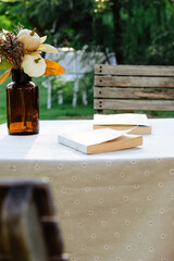 Wooden table with a book and a glass vase with flowers