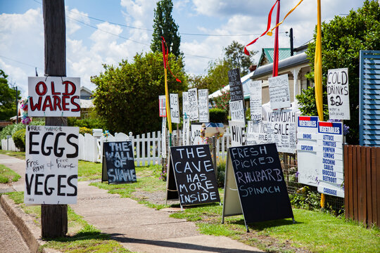 Lots of hand written signs advertising things for sale outside home on street