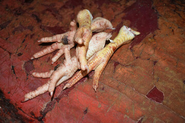 fresh chicken feet in the market, A detailed close-up shot showcasing the texture of fresh chicken feet, highlighting its unique skin pattern, A pile of fresh chicken feet, closeup in chicken shop