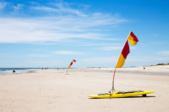 Life saver flags on sandy beach horizontal