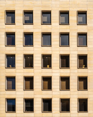 A detailed view of a building facade featuring a repetitive pattern of windows and panels.