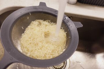 Cooking rice by rinsing it in a colander over a sink