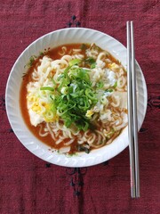 Instant noodles cooked with eggs and sprinkled with spring onions