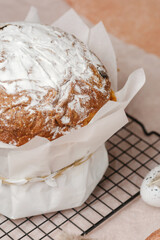 Traditional Easter cake with powdered sugar and speckled eggs on parchment paper. Festive food concept for spring holiday.