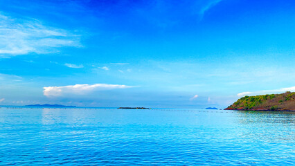 Blue sea with gentle waves under a cloudy sky.