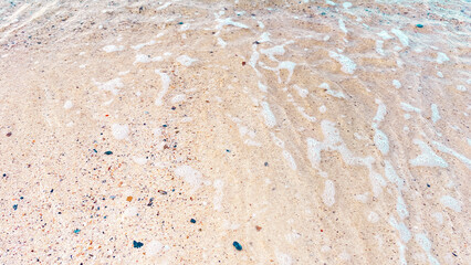 A wide sandy beach with smooth, golden sand under bright daylight.