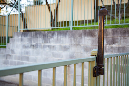Fence beside brick wall with self closing gate