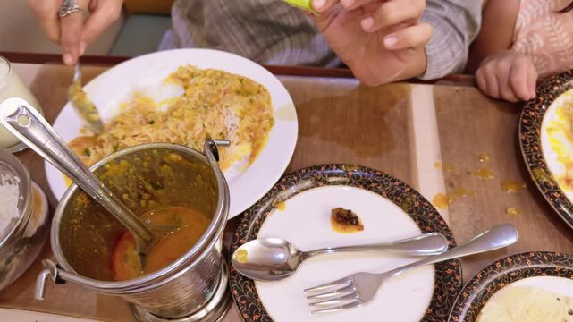 Spoon stirs spiced lentils and grains inside platter
