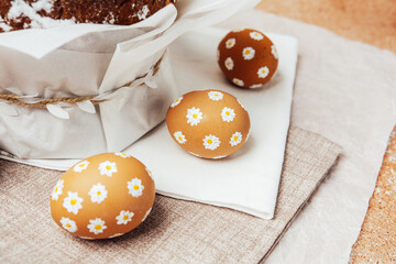 Traditional Easter cake with hand-painted daisy eggs on fabric. Homemade festive baked goods and...