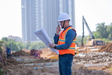 Engineer worker operations construction plans large black drainage pipe installing underground...
