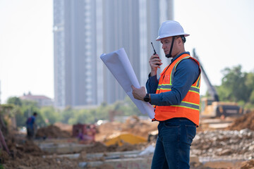 Engineer worker operations construction plans large black drainage pipe installing underground...