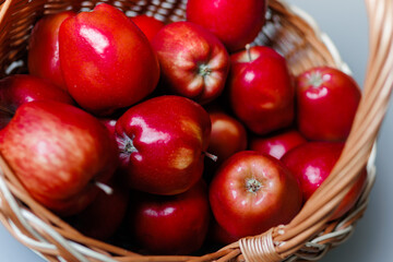 Red apples in a basket on a gray background
