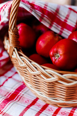 Red apples in a basket covered with a red striped napkin