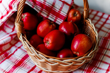 Red apples in a basket covered with a red striped napkin