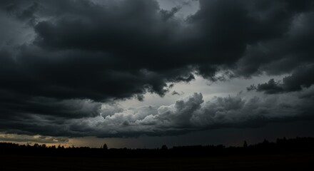 Fototapeta premium Dramatic storm clouds looming over a dark landscape 