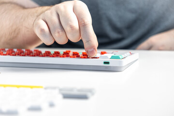 Person pressing white keycap onto red switch during mechanical keyboard customization